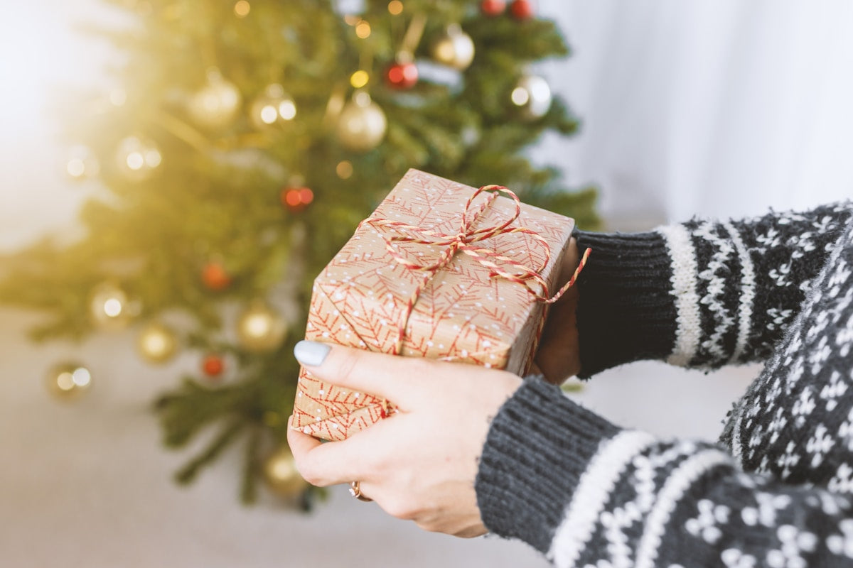 Personne offrant un cadeau emballé avec soin — idée cadeau céramique artisanale
