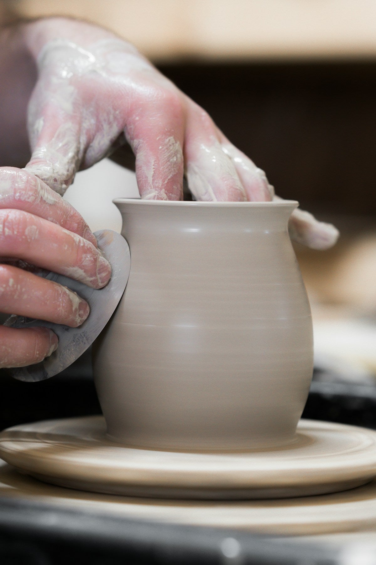 Mains d'artisan tenant un pot en céramique fait main — savoir-faire artisanal